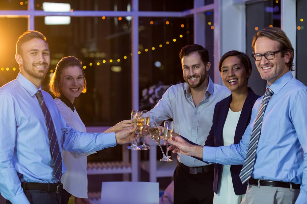 Portrait of businesspeople toasting glasses of champagne in office at night